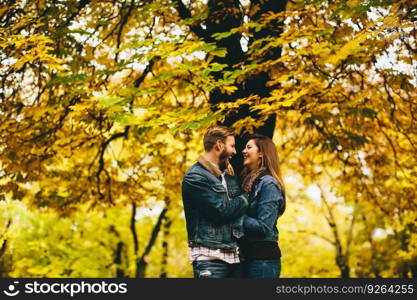 Loving couple exchanging tenderness in the autumn park