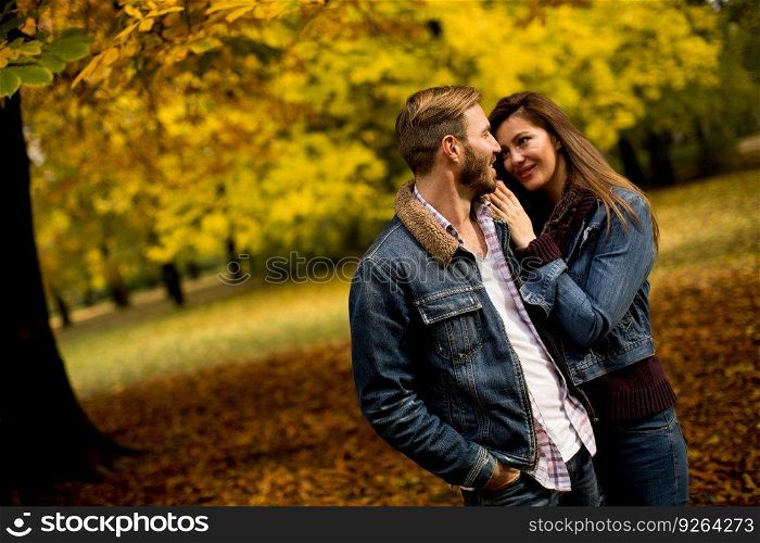 Loving couple exchanging tenderness in the autumn park