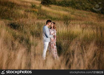 loving couple hold hands and hugging outside in the field at summer. Concept of love and family. copy space.. loving couple hold hands and hugging outside in the field at summer. Concept of love and family. copy space