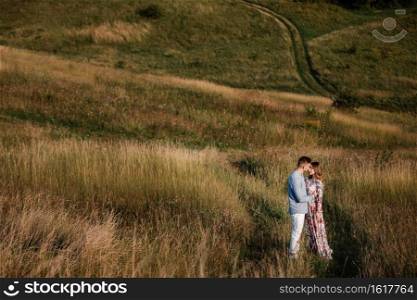 loving couple hold hands and walk outside in the field. Concept of love and family. copy space.. loving couple hold hands and walk outside in the field. Concept of love and family. copy space