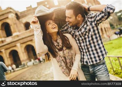 Loving couple in front of the Colosseum in Rome while raining