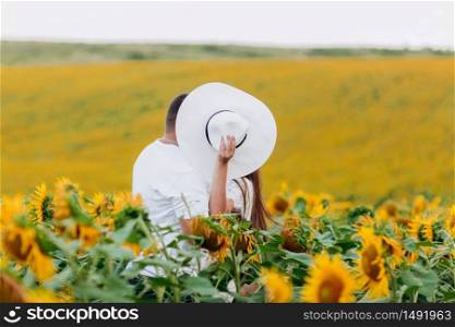 Loving couple kissing in a field of sunflowers. Family spending time together on nature. selective focus.. Loving couple kissing in a field of sunflowers. Family spending time together on nature. selective focus