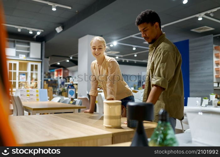 Loving couple looking for table at furniture store. Wife and husband discussing future purchase. Couple looking for table at furniture store