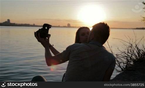 Loving Couple On A Walk. Boy And Girl Kissing And Taking Pictures.