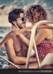 Loving couple on sailboat, two happy lovers kissing and laughing, enjoying romantic date, amazing honeymoon in a sea cruise, active summer vacation