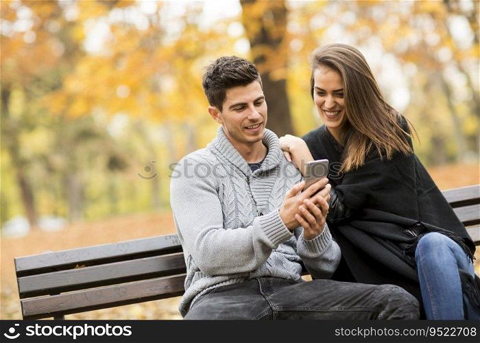 Loving couple on the bench in the autumn park