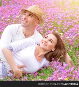 Loving couple on the fresh purple floral field, cuddling outdoors in sunny day, enjoying each other, young family, romance concept