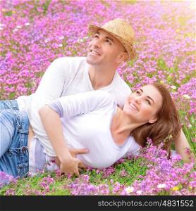 Loving couple on the fresh purple floral field, cuddling outdoors in sunny day, enjoying each other, young family, romance concept