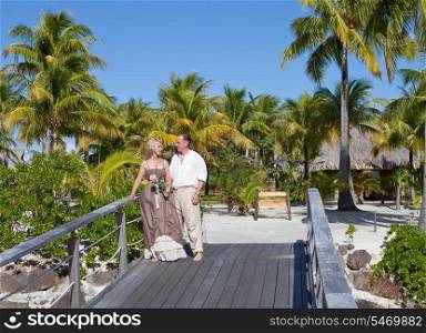Loving couple on the wooden bridge on the tropical island