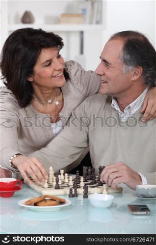 Loving couple playing chess together