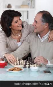 Loving couple playing chess together