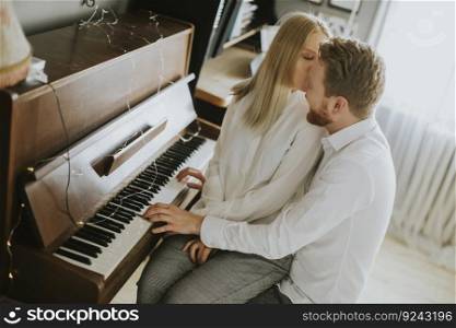 Loving couple playing piano in the room at home