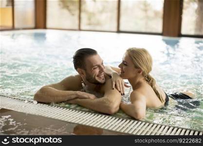 Loving couple relaxing in the pool at spa center
