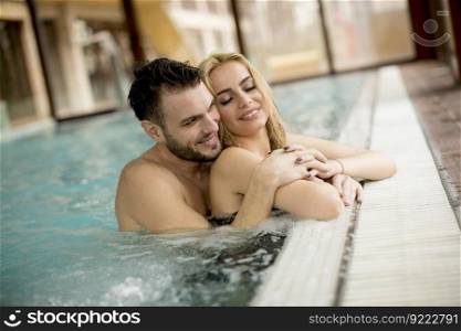 Loving couple relaxing in the pool at spa center