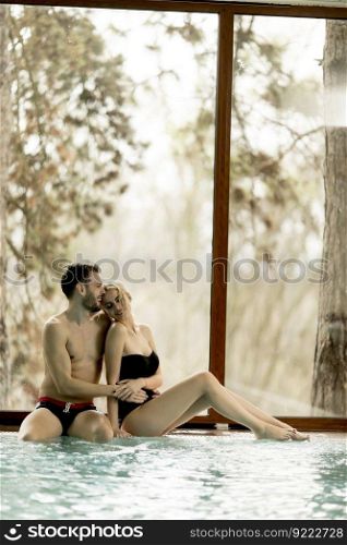 Loving couple relaxing in the spa center by pool