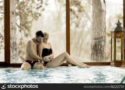 Loving couple relaxing in the spa center by pool