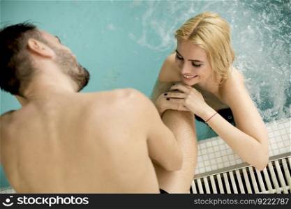 Loving couple relaxing in the spa center by pool