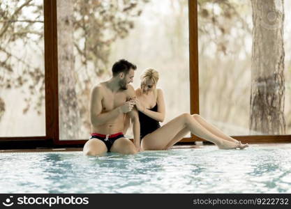 Loving couple relaxing in the spa center by the  pool