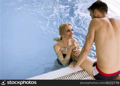 Loving couple relaxing in the spa center by the swimming pool