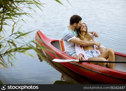 Loving couple rowing on the calm lake at summer day