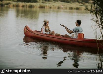 Loving couple rowing on the lake at summer day