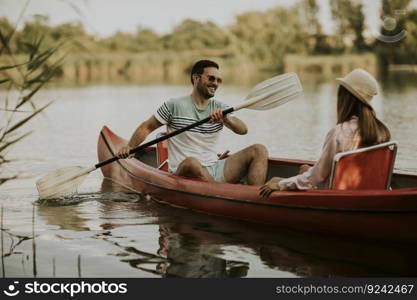 Loving couple rowing on the lake at summer day