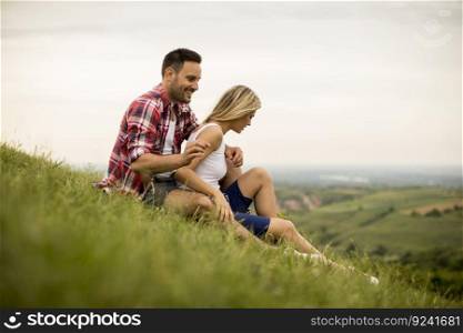 Loving couple sitting  hugged on the grass in the mountain