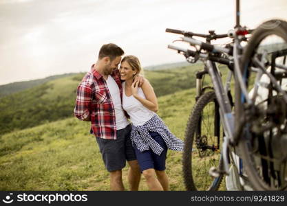 Loving couple stnding next to the car with bicycles in the nature