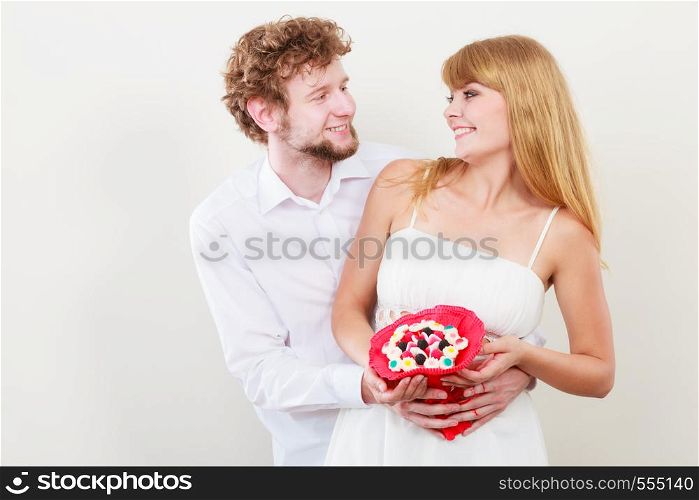 Loving couple with candy bunch bouquet flowers. Handsome man and pretty woman holding present gift. Relationship love concept.. Loving couple with candy bunch flowers. Love.