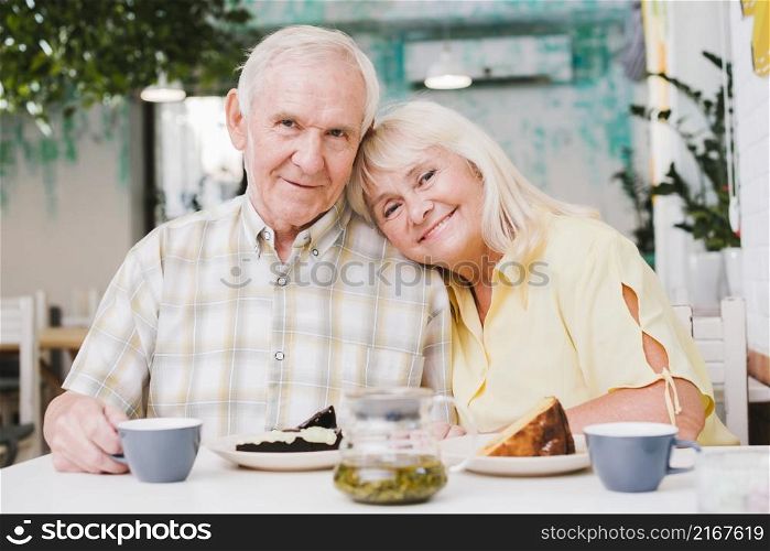 loving elderly couple drinking tea eating cake
