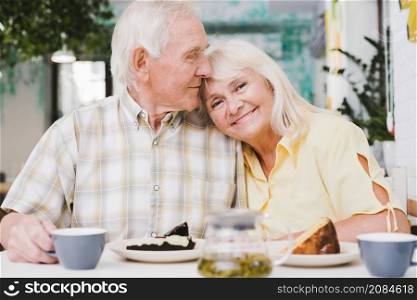 loving elderly couple drinking tea with cake