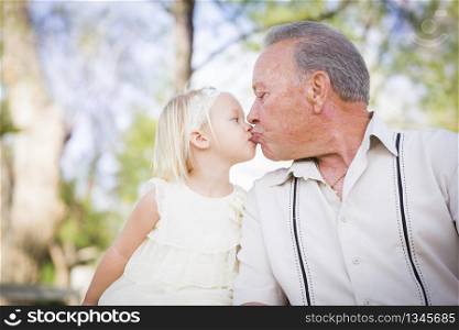 Loving Grandfather and Granddaughter Kissing Outside At The Park.