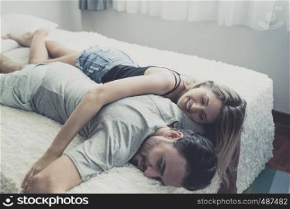 Loving happy couple in love smile and hug each other on the bed, in big bedroom, Love story concept