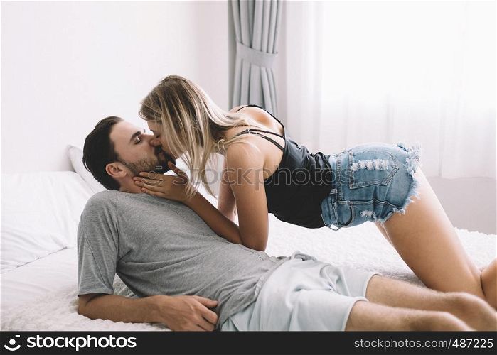 Loving happy couple in love smile kissing and hug each other on the bed, in big bedroom, Love story concept