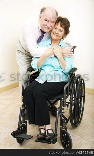 Loving middle-aged husband and wife. She is in a wheelchair.