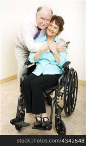 Loving middle-aged husband and wife. She is in a wheelchair.