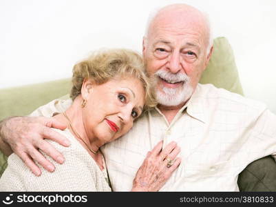 Loving senior couple at home relaxing on the couch.