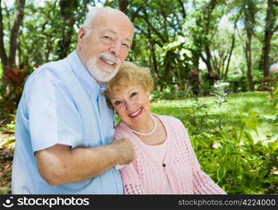 Loving senior couple outdoors in a beautiful natural setting. Plenty of room for text.