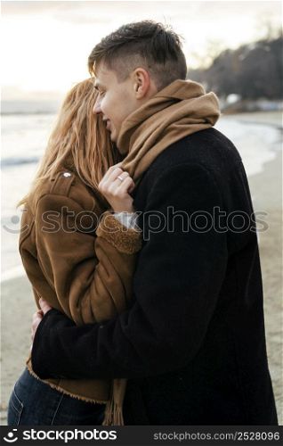 loving young couple embracing beach winter