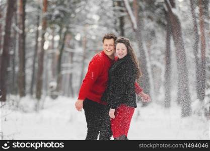 loving young couple having fun with snow in winter forest. loving young couple having fun with snow in winter forest.