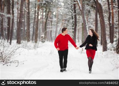loving young couple having fun with snow in winter forest. Guy and girl enjoying a walk. loving young couple having fun with snow in winter forest. Guy and girl enjoying a walk.