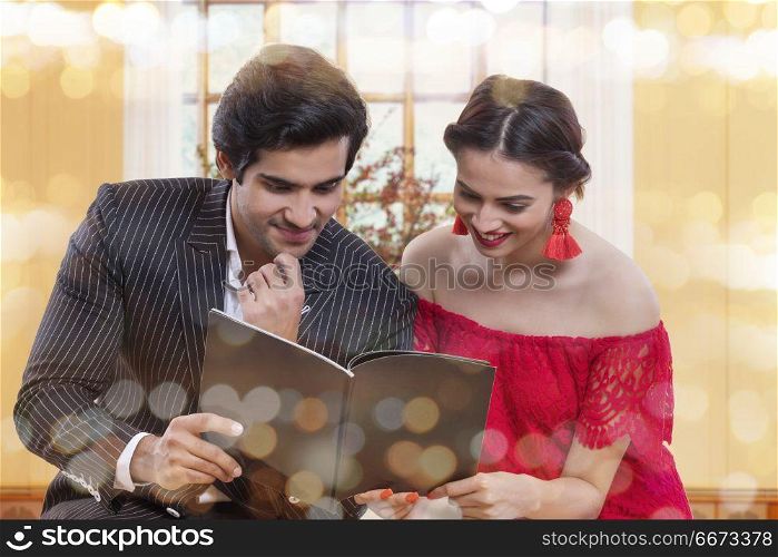 loving young couple holding book spending time together at home