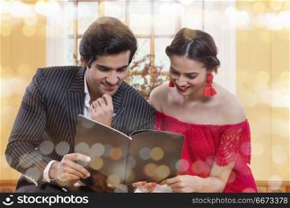 loving young couple holding book spending time together at home
