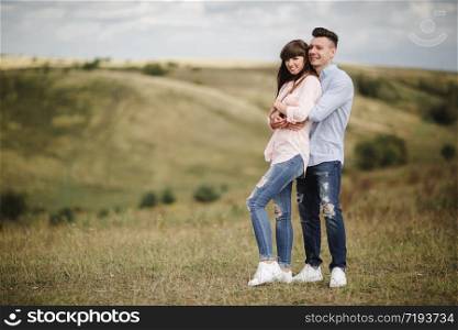 Loving young couple kissing and hugging in outdoors. Love and tenderness, dating, romance, family,. Loving young couple kissing and hugging in outdoors. Love and tenderness, dating, romance, family, anniversary concept.