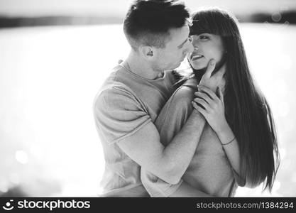 Loving young couple kissing and hugging in outdoors. Love and tenderness, dating, romance, family concept.. Loving young couple kissing and hugging in outdoors. Love and tenderness, dating, romance, family, anniversary concept.