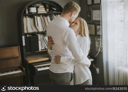 Loving young couple laughing, embracing and  having fun in the room