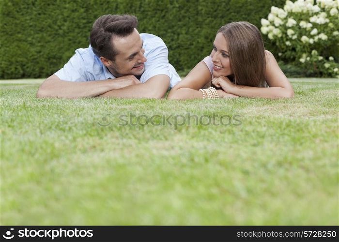 Loving young couple looking at each other while relaxing in park