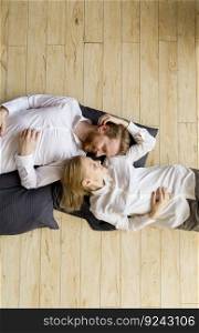 Loving young couple lying and kissing on the floor at home