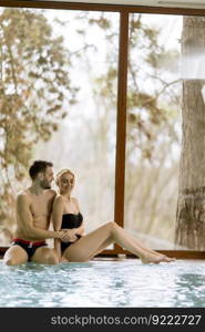 Loving young couple relaxing in the spa center by swimming pool