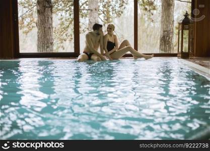 Loving young couple relaxing in the spa center by swimming pool